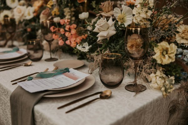 Table decor pink white roses flowers candles cutlery and wine glasses