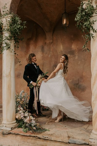 Muted Rainbow Styled Shoot couple holding bouquet of flowers over the shoulder smile