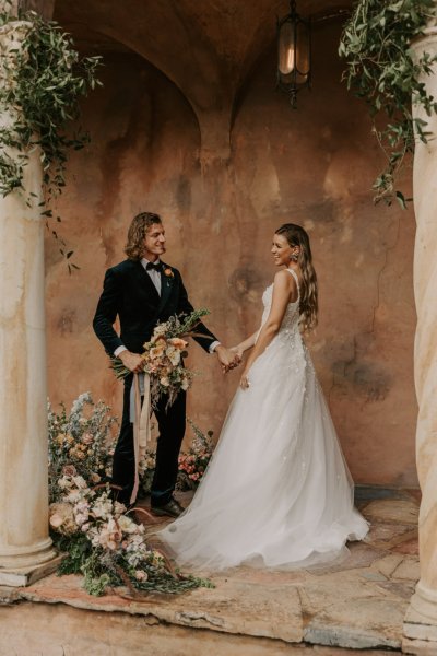 Muted Rainbow Styled Shoot couple holding bouquet of flowers holding hands