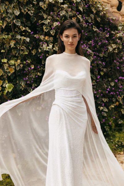 Monique Lhuillier Bridal bride outside in garden long cape