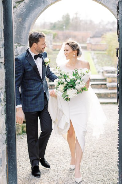 Bride and groom walking holding flowers