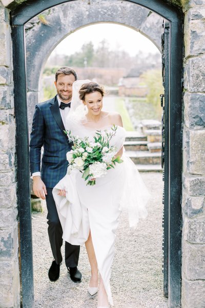 Bride and groom walking holding flowers