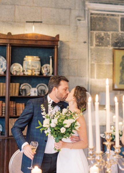 Bride and groom dining room candles lighting kissing kiss