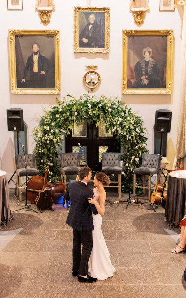 Bride and groom in front of flowers portraits in background