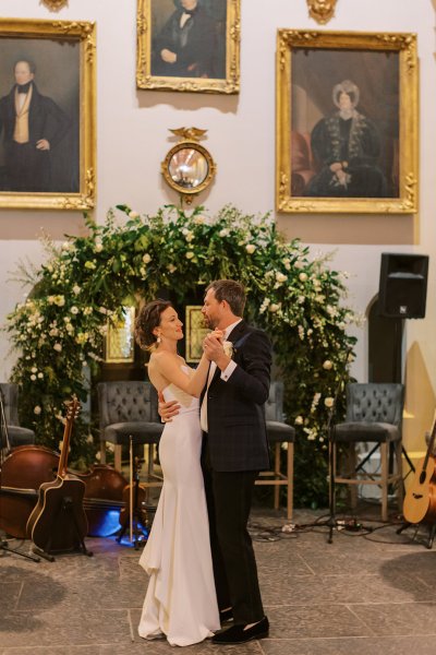 Bride and groom in front of flowers portraits in background