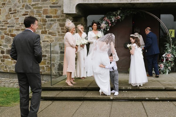 Bride hugs little boy outside of church