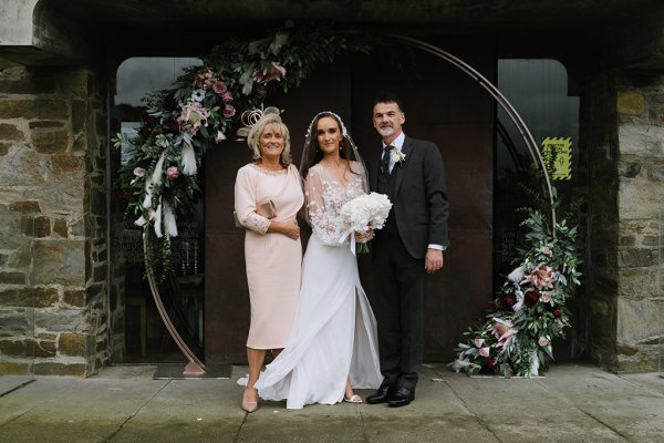 Bride with mother and father outside of venue church