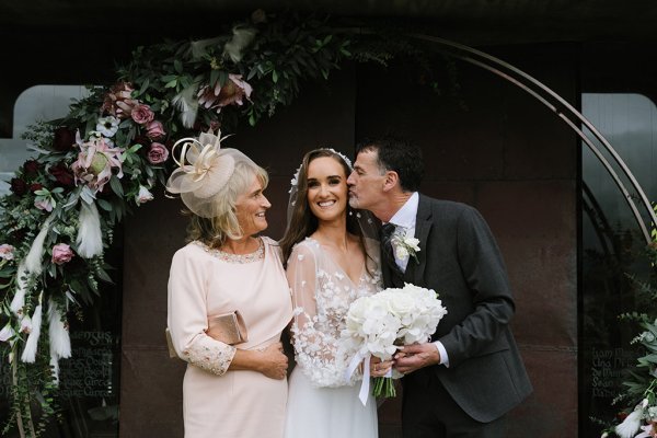 Bride with mother and father outside of venue church