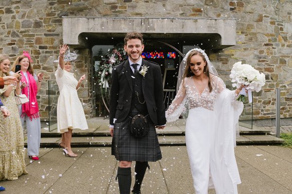 Bride and groom confetti exterior guests