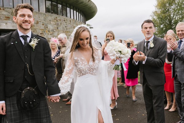 Bride and groom confetti exterior guests