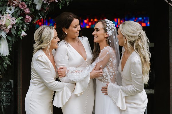 Bridesmaids bride smiling hugging