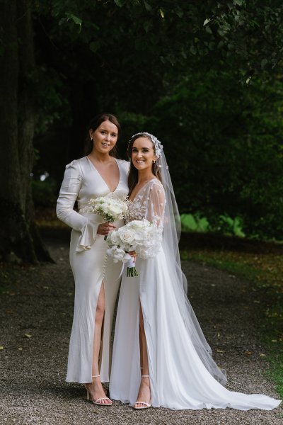 Bride and bridesmaid evening shot white dresses flowers