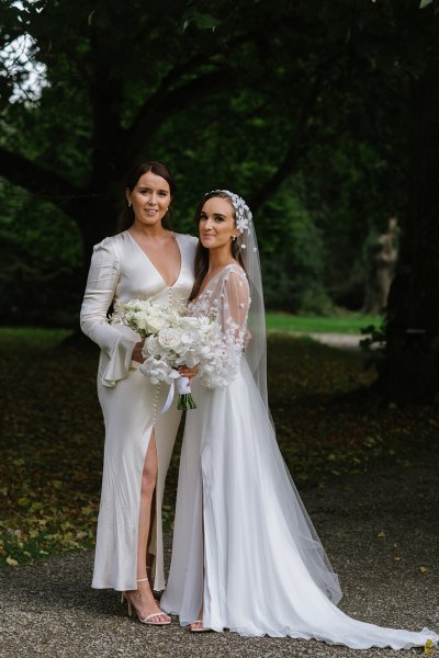 Bride and bridesmaid evening shot white dresses flowers