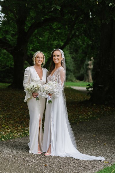 Bride and bridesmaid evening shot white dresses flowers