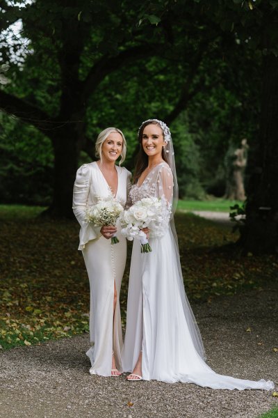 Bride and bridesmaid evening shot white dresses flowers