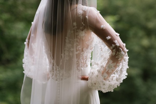 Bride on her own back of dress lace and veil detail