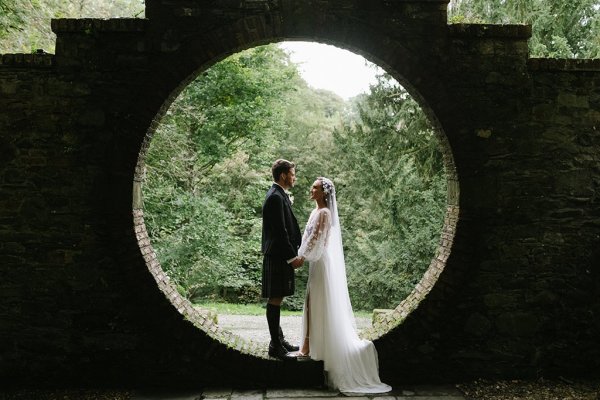 Bride and groom in garden under circular frame