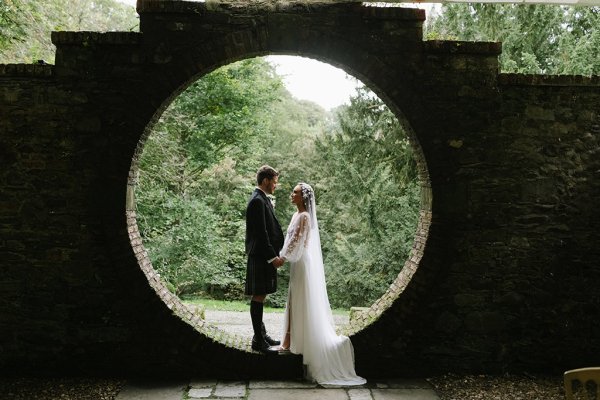 Bride and groom in garden under circular frame