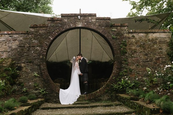 Bride and groom in garden under circular frame