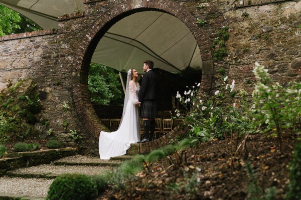 Bride and groom in garden under circular frame