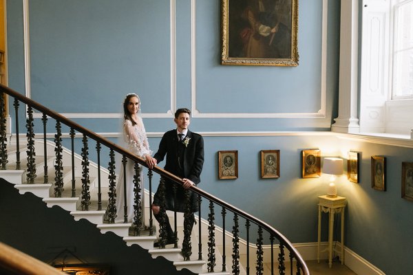 Bride and groom standing on stairs frames on walls