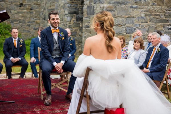 Bride and groom seated at alter with officiant