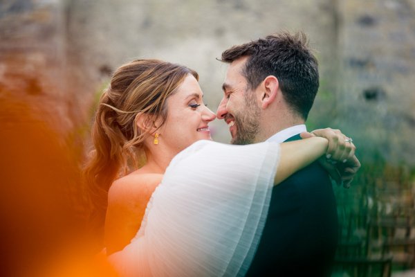 bride and groom touch noses look at each other