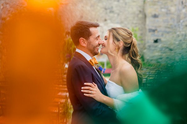 Bride and groom kiss look at each other smiling