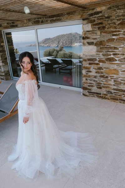 Bride stands at pool in wedding gown ready