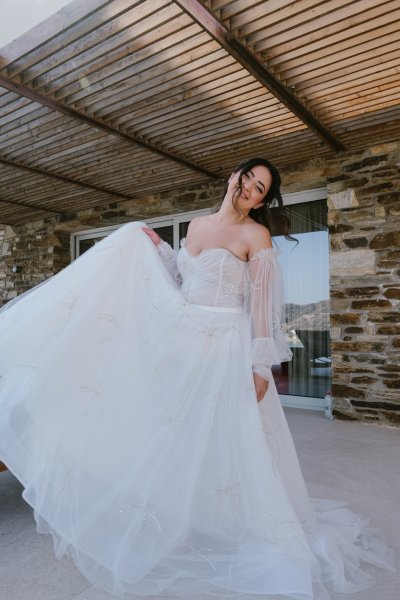 Bride stands at pool in wedding gown ready