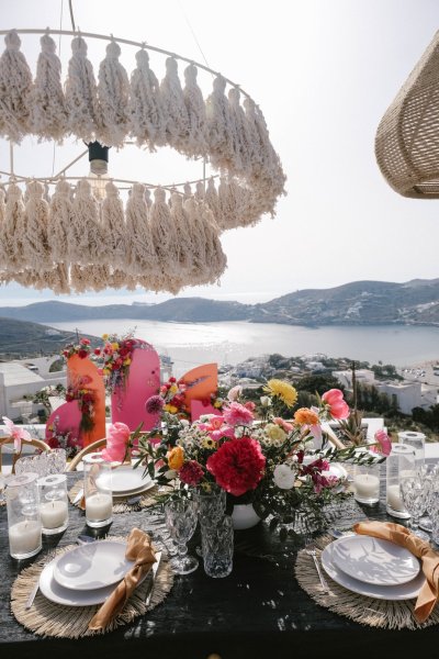 Flowers on dining room table lights cutlery guests food