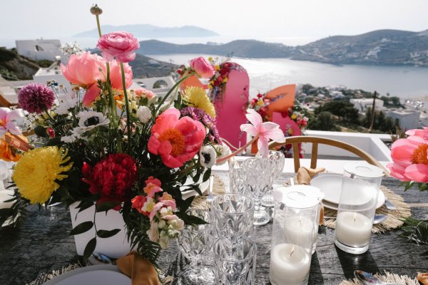 Flowers on dining room table lights cutlery guests food and candles