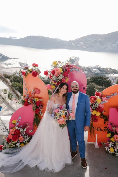 Bride and groom in front of pink setting flowers roses