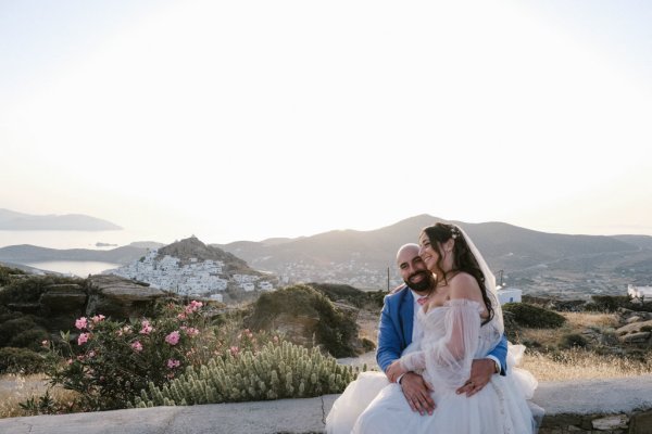 Bride sits on grooms lap exterior mountain view