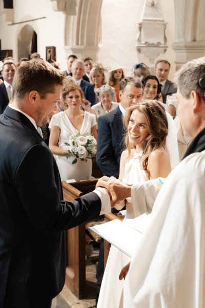 Bride groom and officiant bound with ribbon smiling