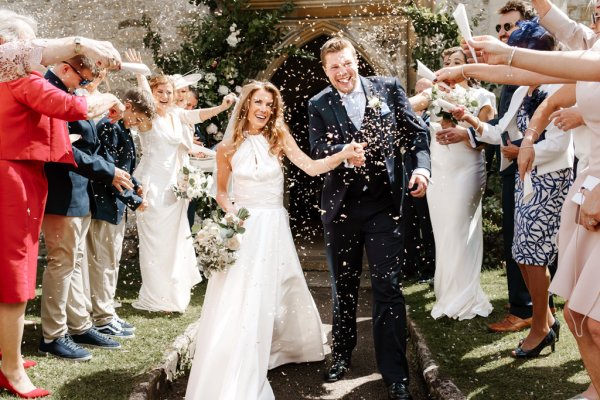 Bride and groom celebrate confetti over couple