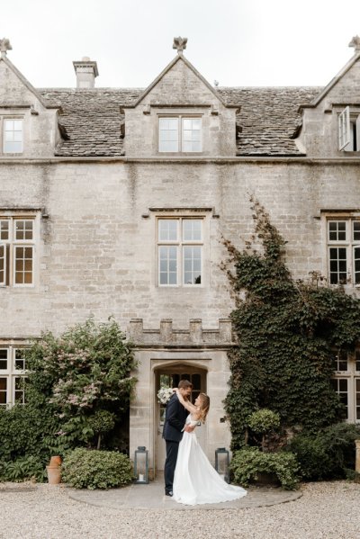 Bride and groom dance outside of wedding venue flowers