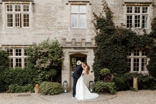 Bride and groom dance outside of wedding venue flowers