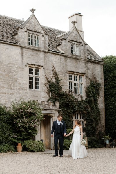 Bride and groom dance outside of wedding venue flowers