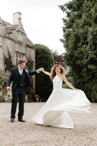 Bride and groom dance outside of wedding venue flowers