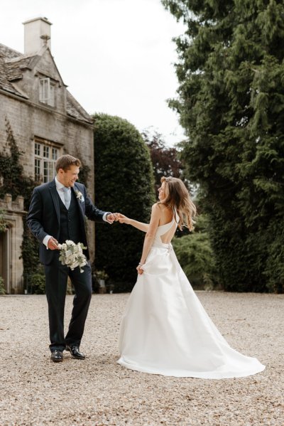 Bride and groom dance outside of wedding venue flowers