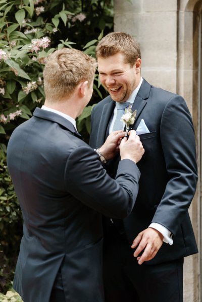 Groom and groomsman laugh