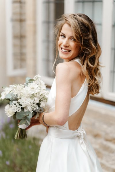 Bride is ready holding bouquet of flowers over the shoulder