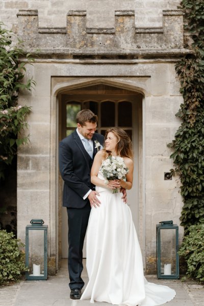 Bride and groom stand outside wedding venue