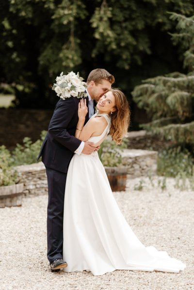 Bride and groom embrace flower detail