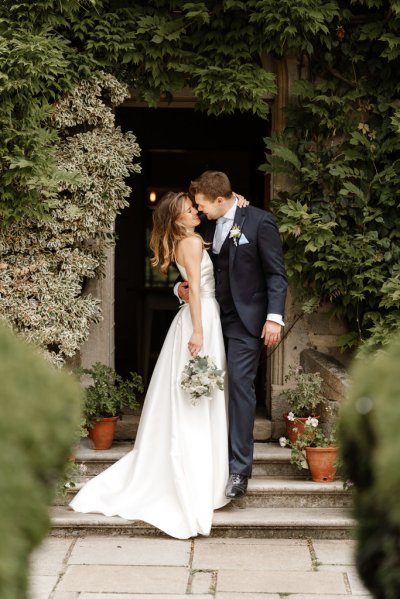 Bride and groom stand outside wedding venue