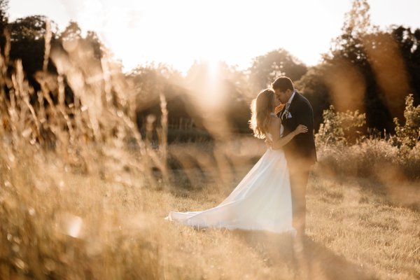 Sun is shining on bride and groom in garden setting