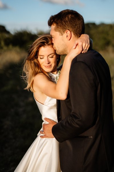 Sun is shining on bride and groom in garden setting