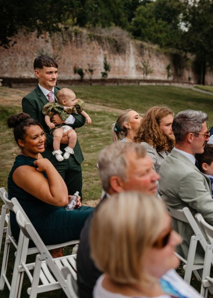 Man holds little baby guests seated