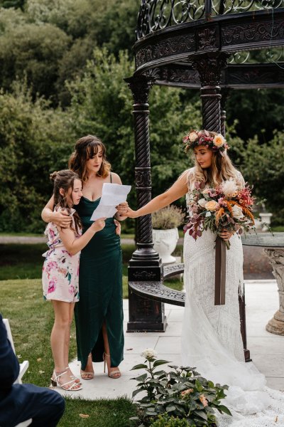 Exterior speech bridesmaid bride groom and officiant little girl